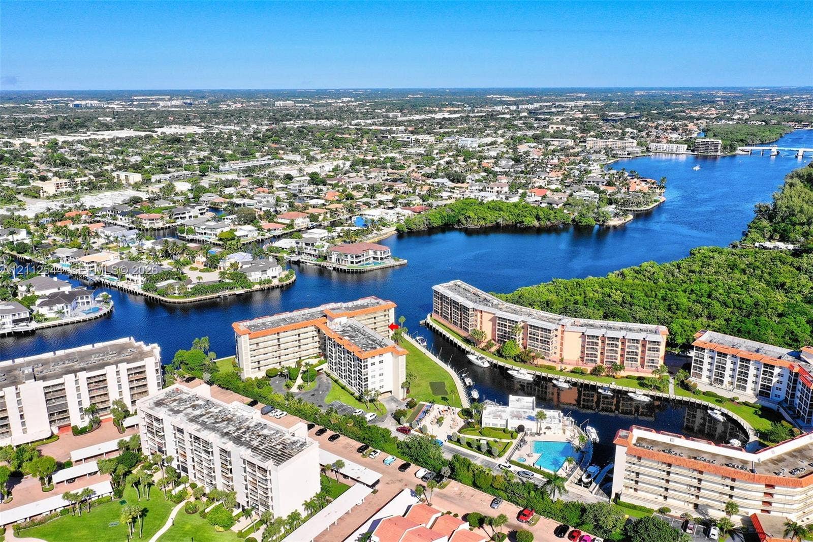 2871 N Ocean Boulevard, #R360, Boca Raton, Boca Raton, FL 33431 Aerial perspective of waterfront mid-rise structures featuring integrated boat slips, open-air parking, and a communal swimming pool