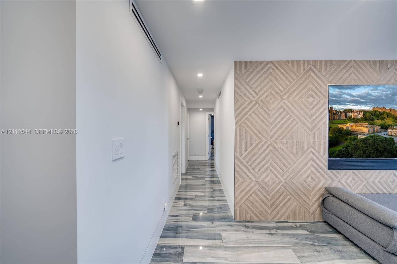 2871 N Ocean Boulevard, #R360, Boca Raton, Boca Raton, FL 33431 Hallway featuring large-format polished tile flooring, geometric wood-patterned accent wall, and recessed ceiling lighting