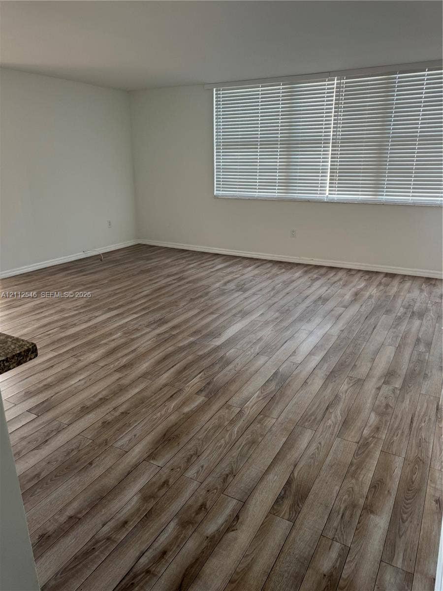 1301 NE Miami Gardens Drive, #515W, Miami, Miami, FL 33179 Interior room featuring wood-finish flooring, neutral wall tones, and horizontal window blinds