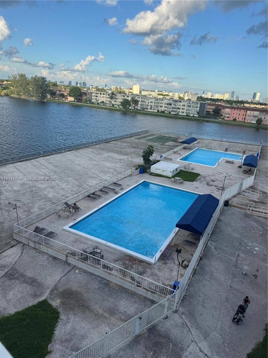1301 NE Miami Gardens Drive, #515W, Miami, Miami, FL 33179 Waterfront community amenities featuring two in-ground swimming pools, concrete pool deck, and fabric shade awnings