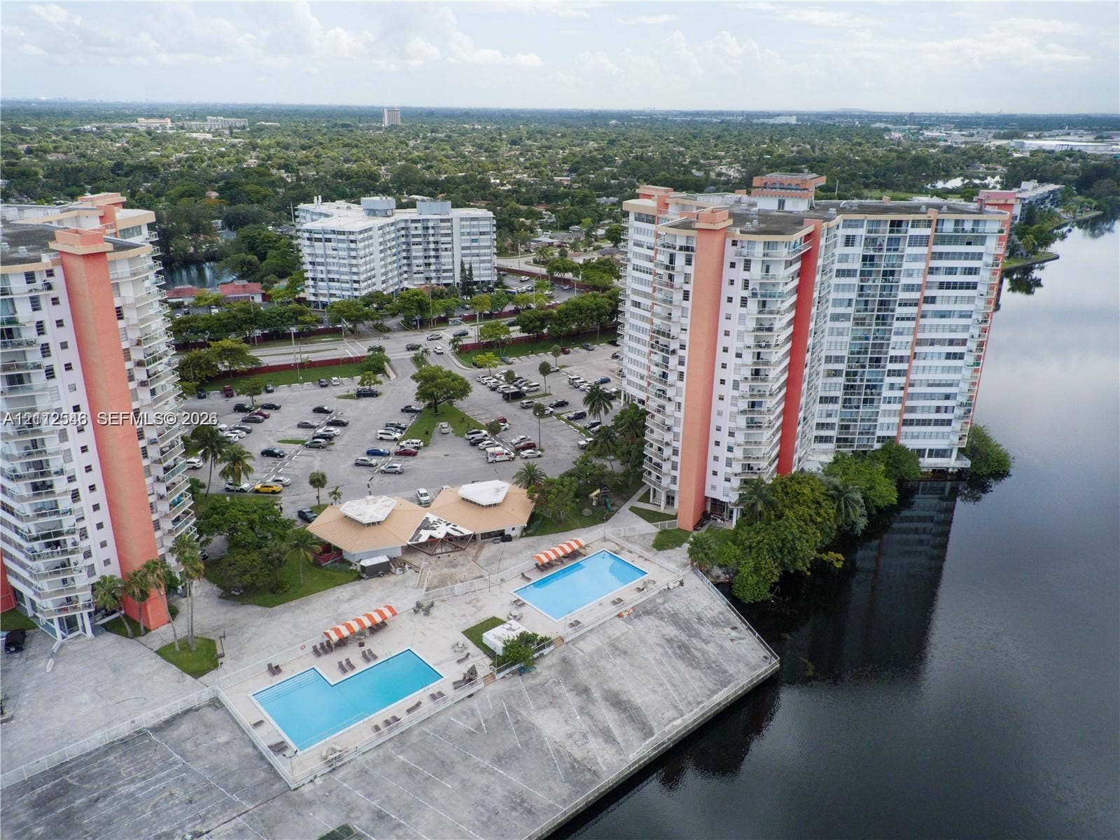 1301 NE Miami Gardens Drive, #515W, Miami, Miami, FL 33179 High-rise residential complex featuring multiple swimming pools, concrete sun decks, and waterfront positioning