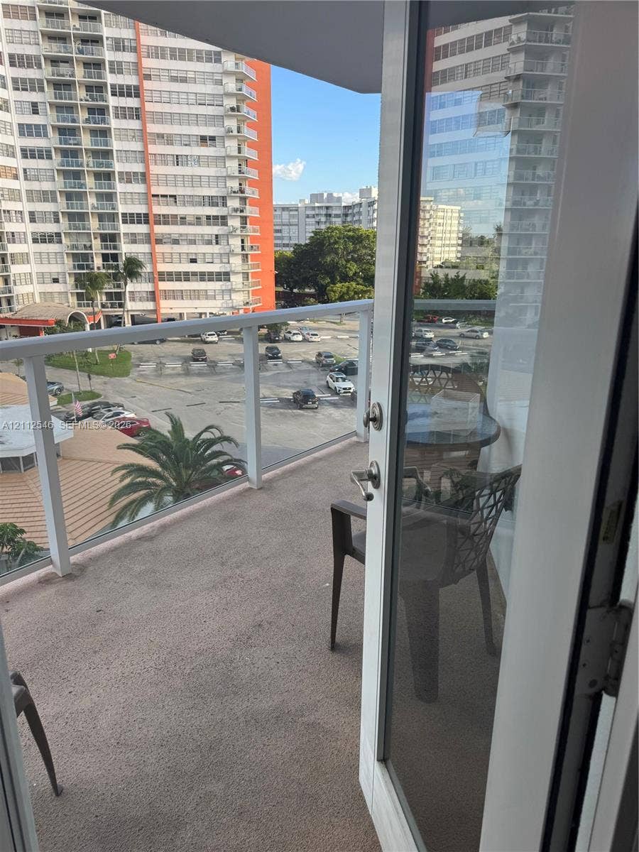 1301 NE Miami Gardens Drive, #515W, Miami, Miami, FL 33179 Private balcony featuring a concrete floor and a glass panel railing with a white frame