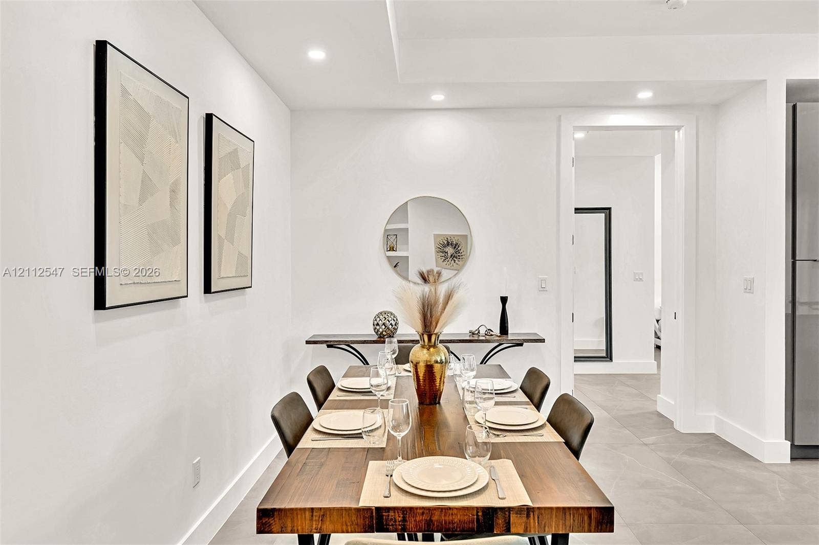 Neutral interior space featuring recessed ceiling lighting, a tray ceiling detail, tile flooring, and a built-in wall niche