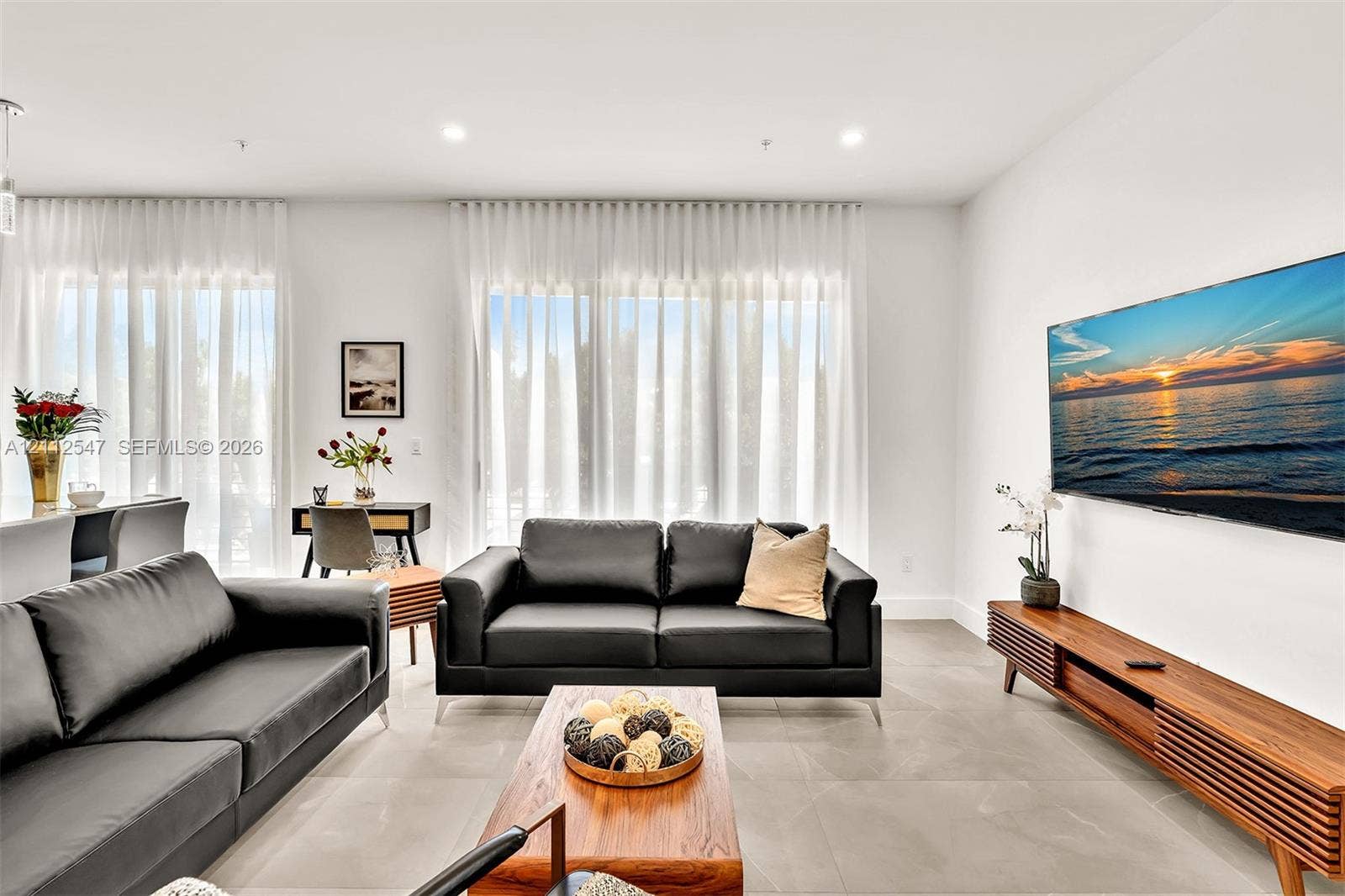 Open-concept space featuring large-format tile flooring, recessed ceiling lighting, and floor-to-ceiling windows
