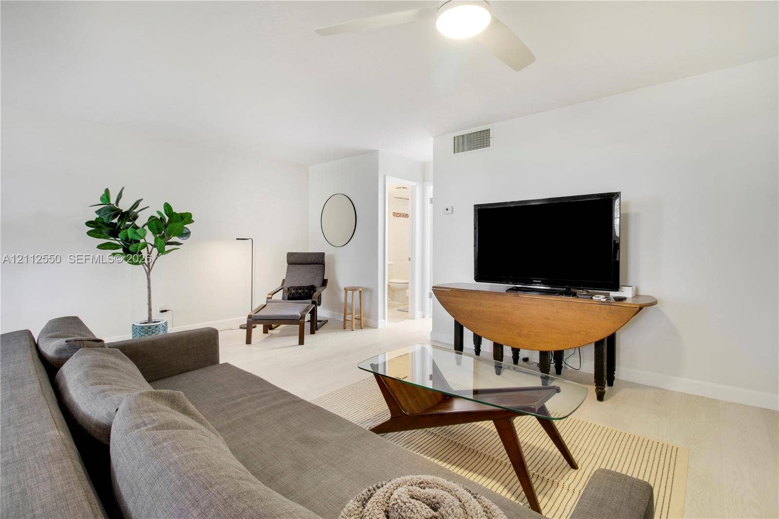 Neutral wall finishes, light-toned wood-finish flooring, and a ceiling-mounted light fixture