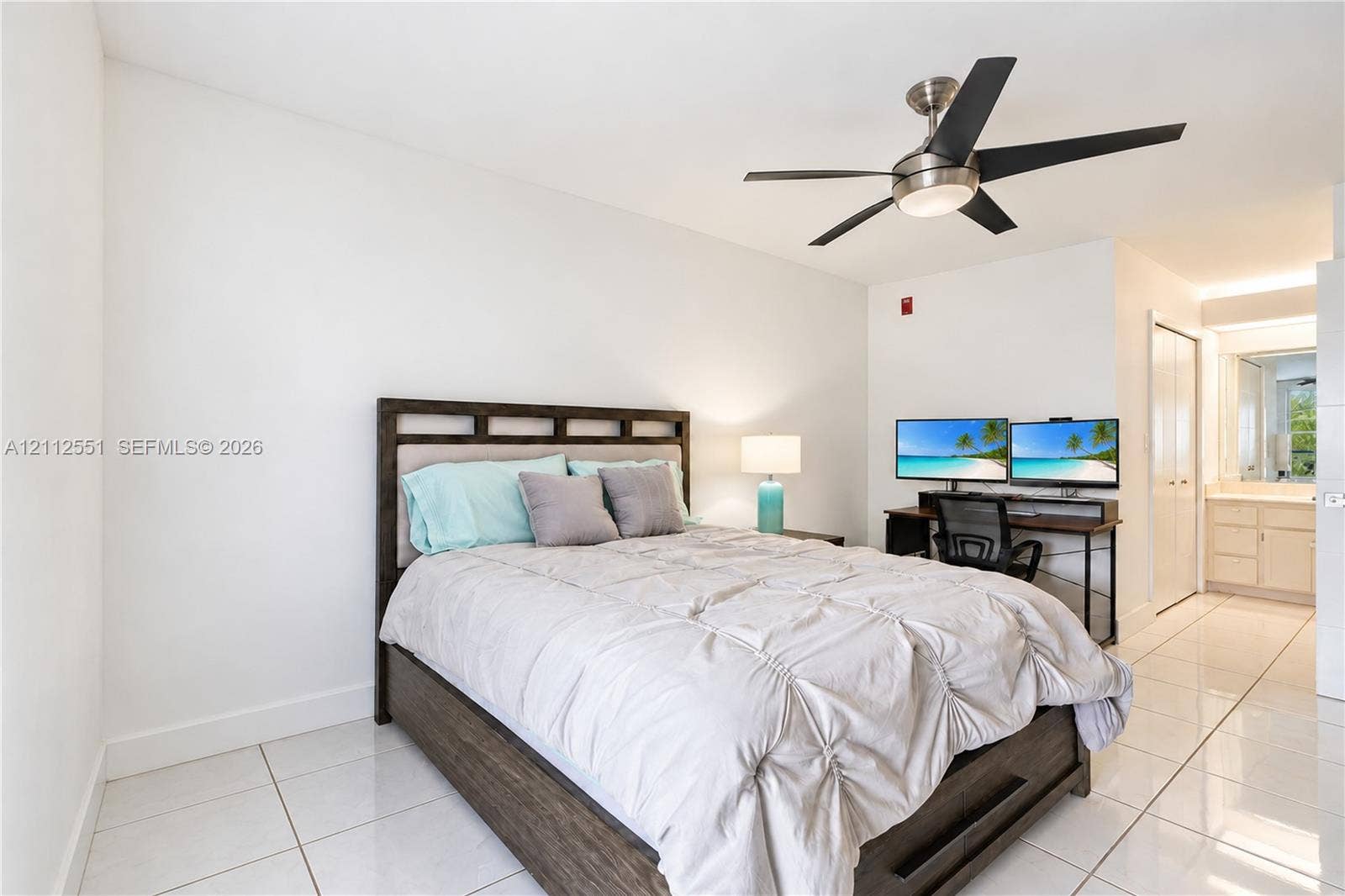 Polished tile flooring, neutral wall finishes, and a brushed nickel ceiling fan with integrated lighting