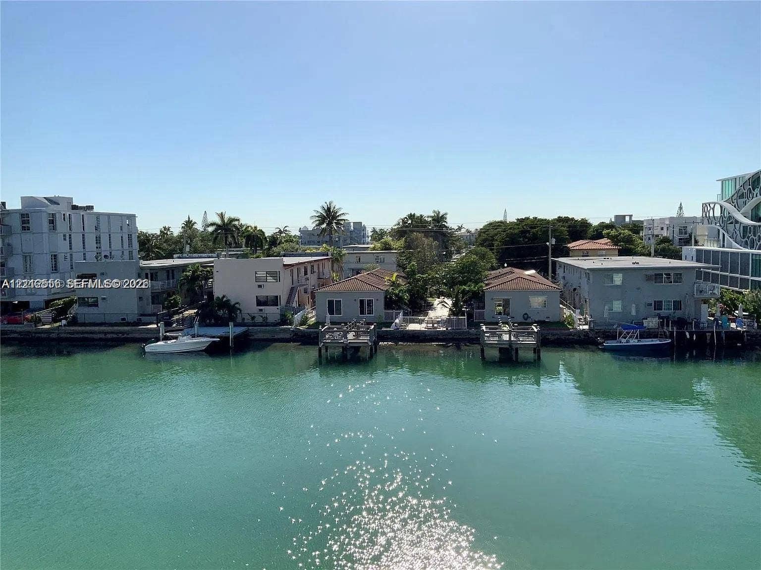 8400 Byron Avenue, #4E, Miami Beach, Miami Beach, FL 33141 Waterfront property featuring private docks, concrete seawalls, and tropical landscaping