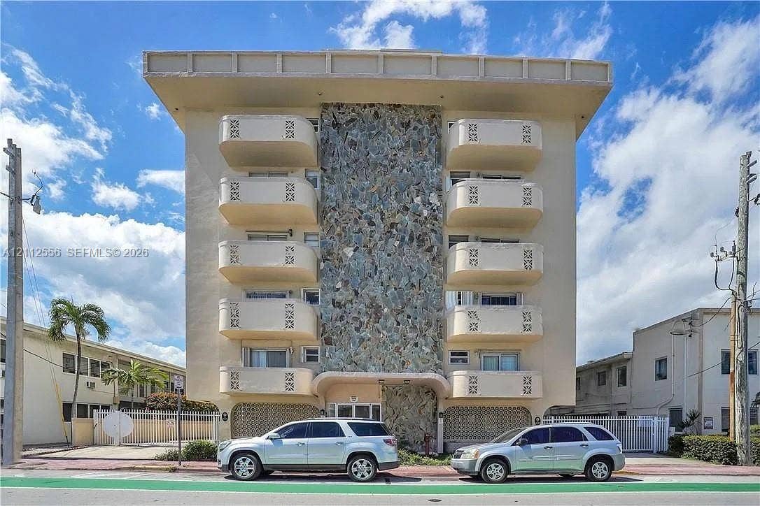 8400 Byron Avenue, #4E, Miami Beach, Miami Beach, FL 33141 Mid-century modern architectural facade featuring a central stone-clad vertical accent, cantilevered balconies with geometric patterned railings, and a distinct horizontal roofline