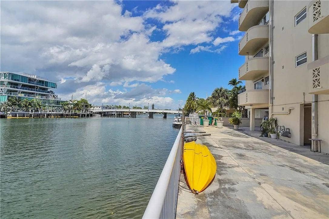 8400 Byron Avenue, #4E, Miami Beach, Miami Beach, FL 33141 Waterfront concrete patio featuring a metal railing, multi-level balconies, and direct water access