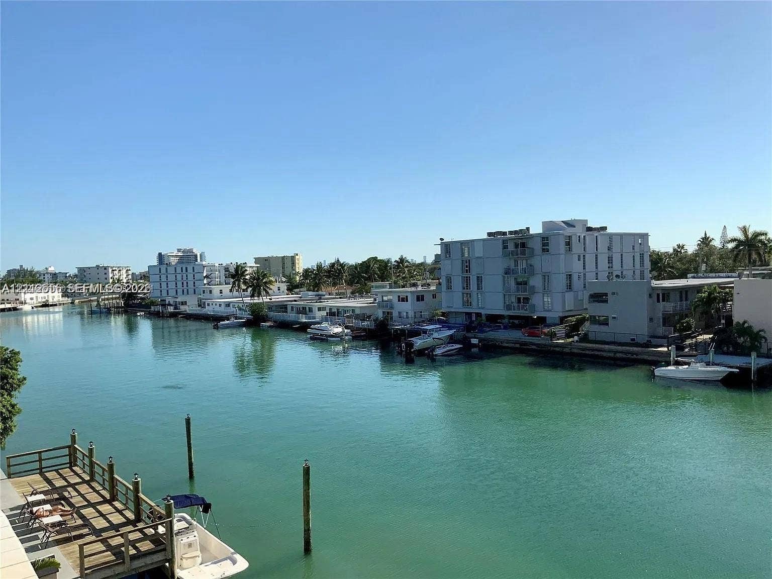 8400 Byron Avenue, #4E, Miami Beach, Miami Beach, FL 33141 Waterfront property featuring a private wooden dock, concrete seawall, and direct waterway access