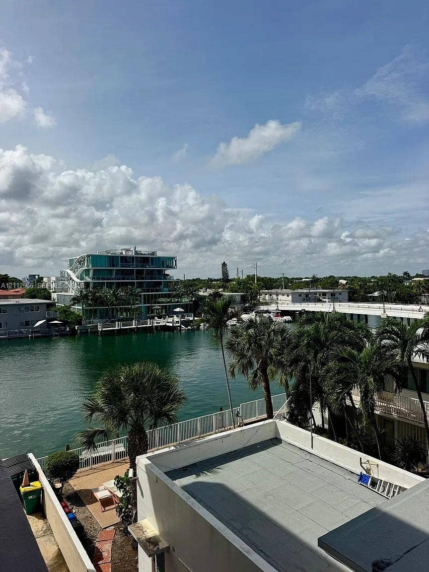 8400 Byron Avenue, #4E, Miami Beach, Miami Beach, FL 33141 Waterfront property featuring a canal, palm trees, and structural hardscaping