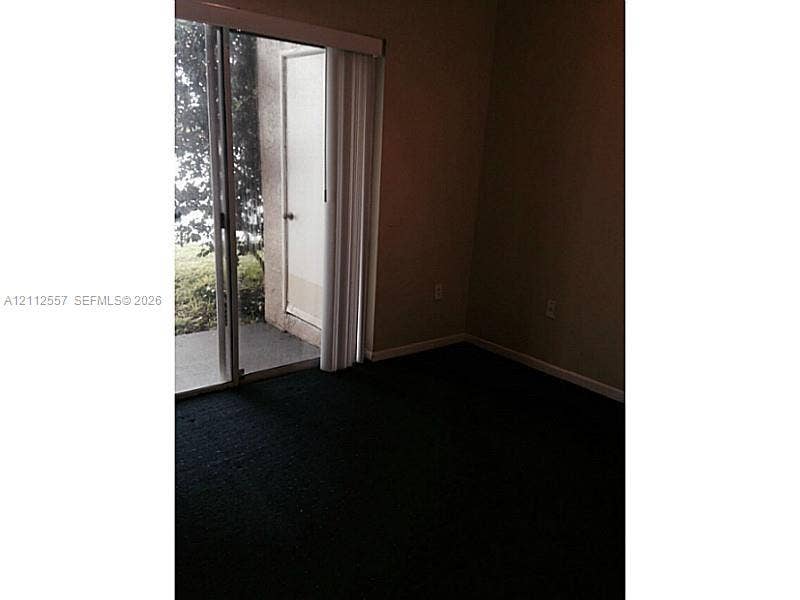 2121 NW 96th Terrace, #14J, Pembroke Pines, Pembroke Pines, FL 33024 Sliding glass door with vertical blinds opening to a concrete patio