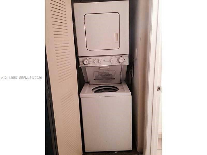 2121 NW 96th Terrace, #14J, Pembroke Pines, Pembroke Pines, FL 33024 Stacked laundry center featuring a top-loading washer, front-loading dryer, and louvered closet door