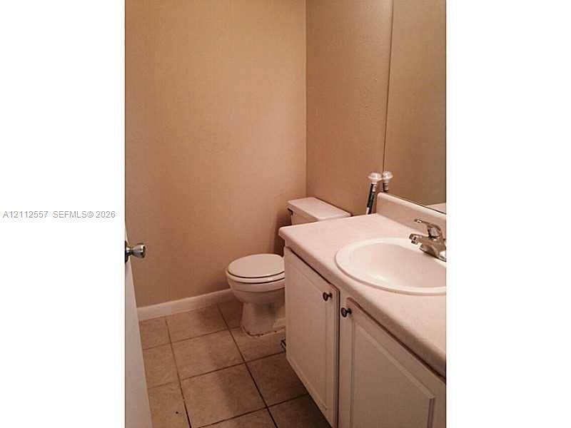 2121 NW 96th Terrace, #14J, Pembroke Pines, Pembroke Pines, FL 33024 Bathroom featuring a vanity with white cabinetry, a single-basin sink, a metal faucet, a large wall-mounted mirror, and ceramic tile flooring
