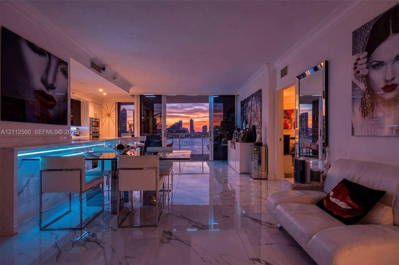 4000 Island Boulevard, #701, Aventura, FL 33160 Open-concept living space featuring large-format polished stone-finish tile flooring, integrated linear LED accent lighting, and floor-to-ceiling sliding glass doors opening to a coastal cityscape and waterfront
