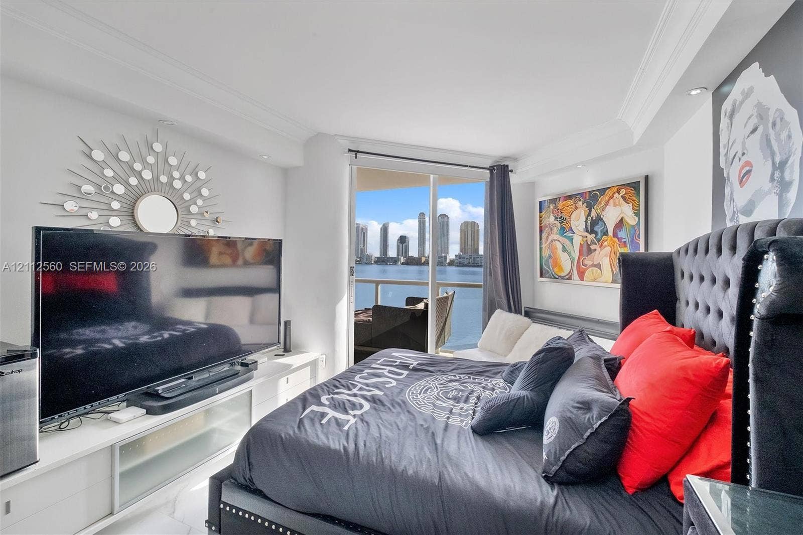4000 Island Boulevard, #701, Aventura, FL 33160 Floor-to-ceiling glass sliding doors opening to a balcony, white stone-finish flooring, recessed ceiling lighting, and crown molding
