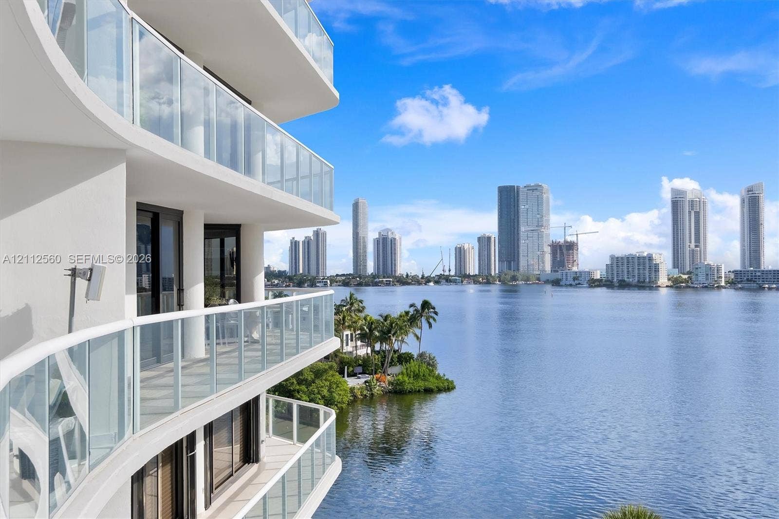 4000 Island Boulevard, #701, Aventura, FL 33160 Multi-level exterior balcony featuring glass panel railings, concrete construction, and dark-framed sliding glass doors