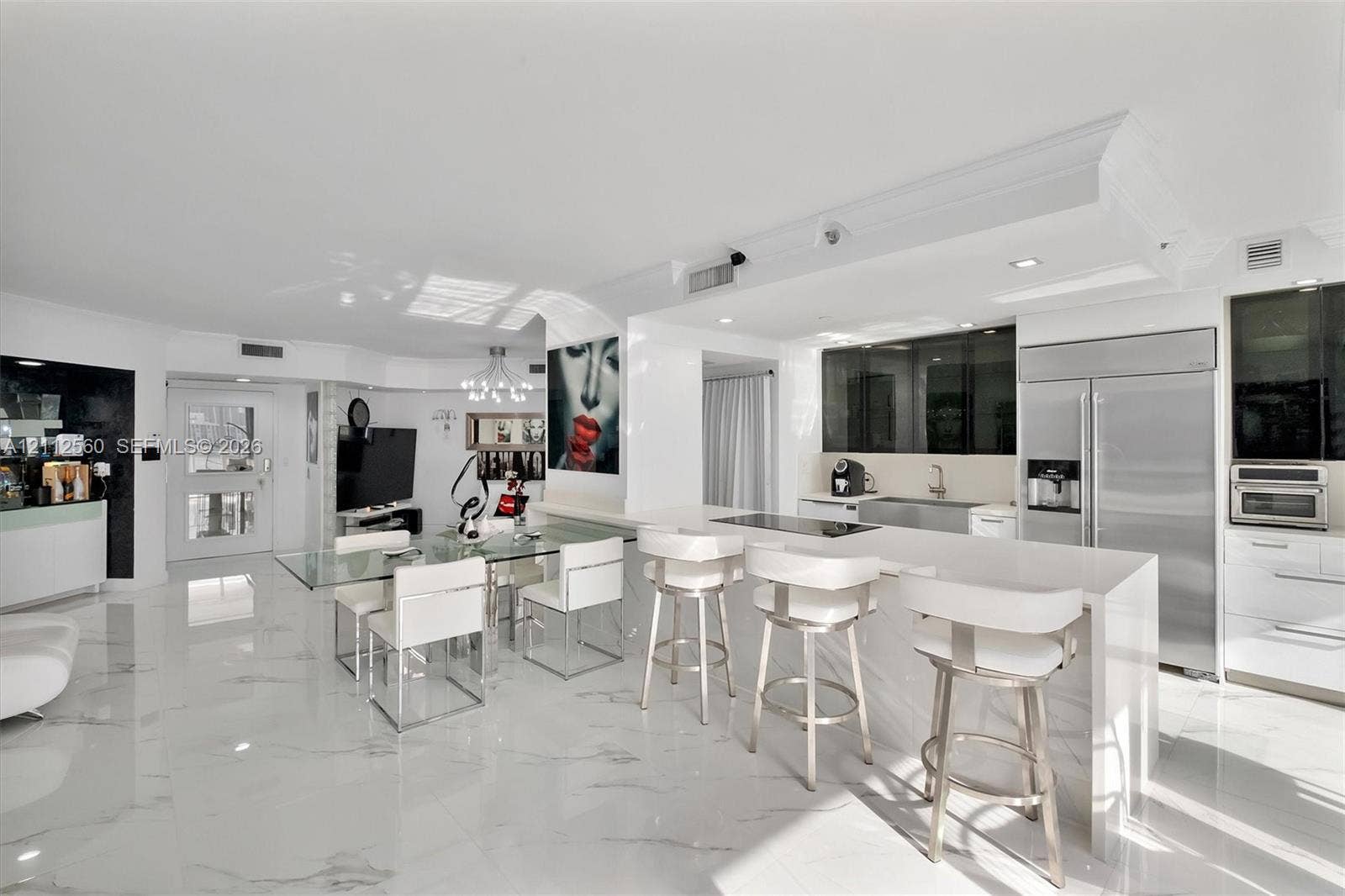 4000 Island Boulevard, #701, Aventura, FL 33160 Open-concept kitchen and living area featuring high-gloss cabinetry, stone-finish countertops, stainless steel appliances, and large-format polished flooring