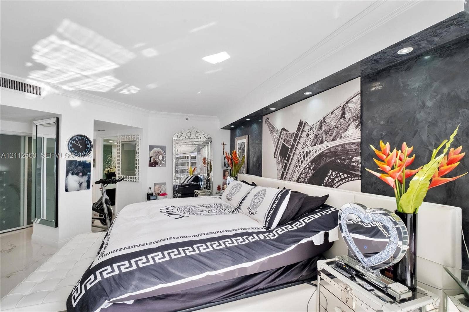 4000 Island Boulevard, #701, Aventura, FL 33160 Custom built-in headboard featuring a textured black accent wall, integrated recessed lighting, and polished stone-finish flooring