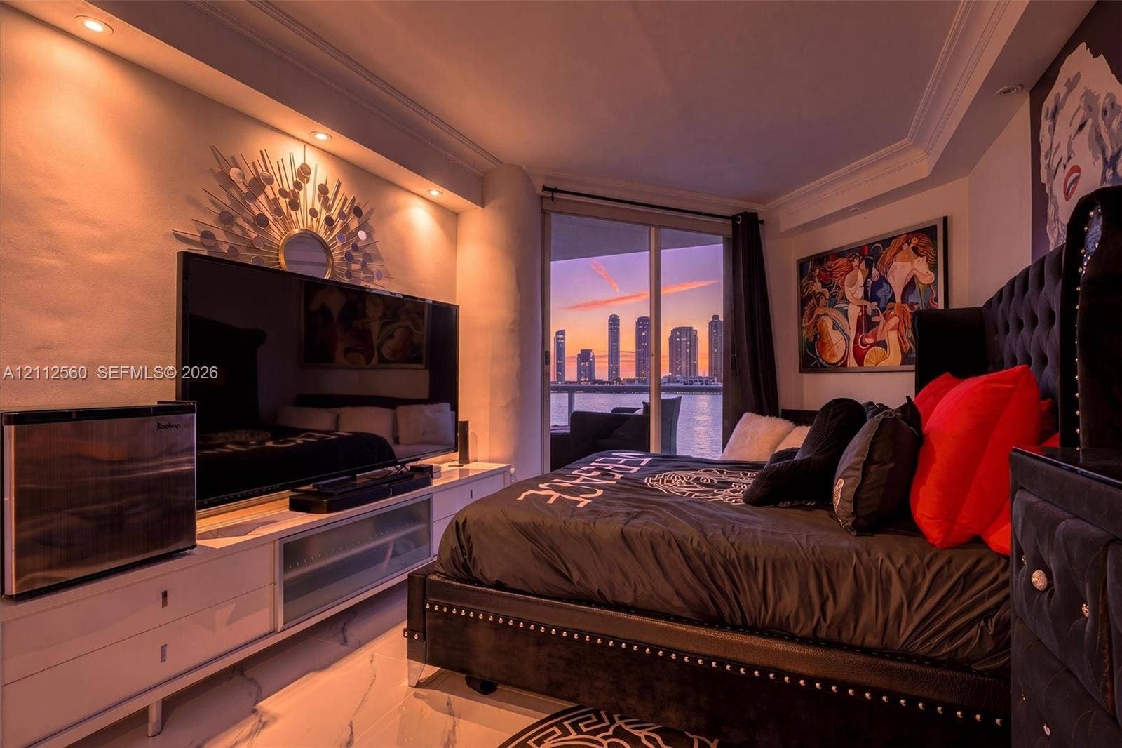 4000 Island Boulevard, #701, Aventura, FL 33160 Custom built-in white cabinetry, recessed ceiling lighting, crown molding, polished stone flooring, and floor-to-ceiling glass sliding doors opening to a water-facing terrace
