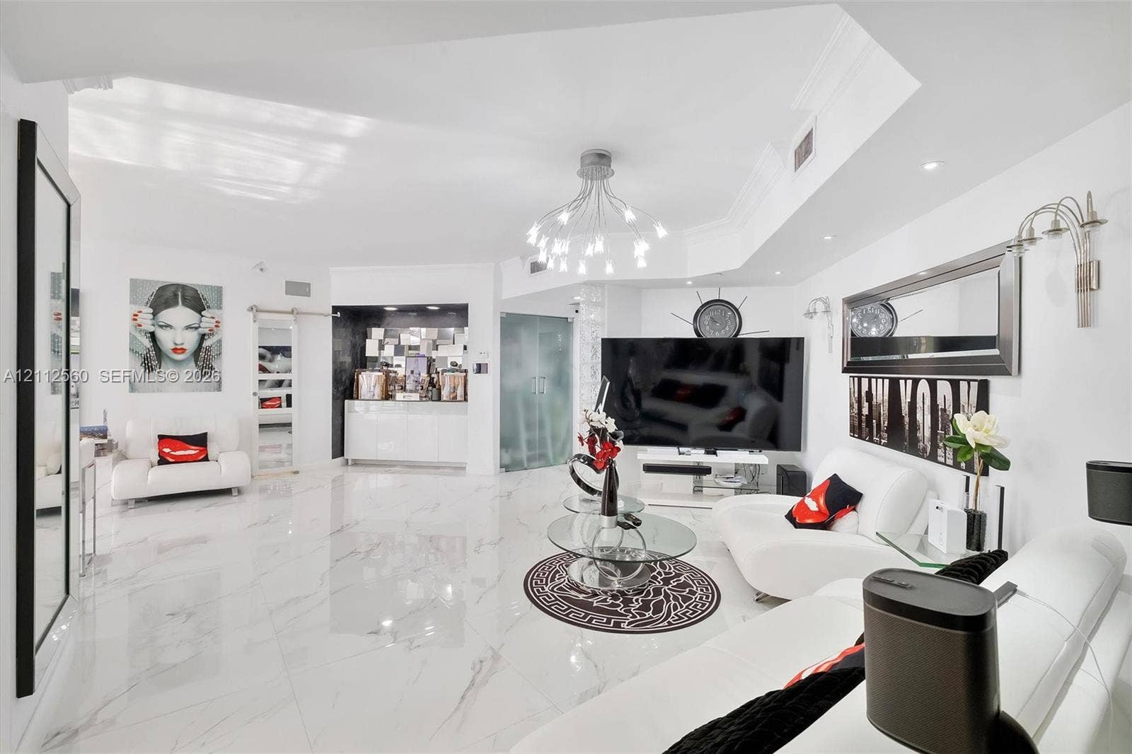 4000 Island Boulevard, #701, Aventura, FL 33160 Large-format polished flooring, recessed ceiling lighting, multi-arm chandelier, built-in wet bar with high-gloss cabinetry, and frosted glass door