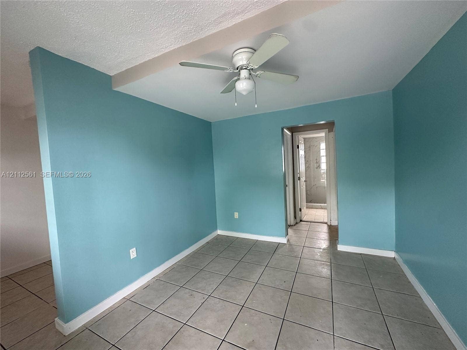 6901 NW 8th Avenue, #2, Miami, Miami, FL 33150 Room featuring neutral tile flooring, light-toned wall finishes, and a central ceiling fan with integrated lighting