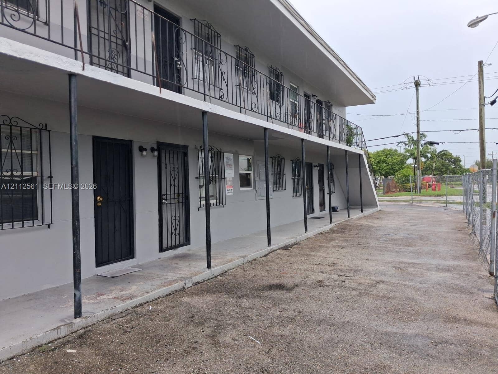 6901 NW 8th Avenue, #2, Miami, Miami, FL 33150 Two-story exterior featuring a concrete facade, metal railings, decorative metal window security bars, and covered porches