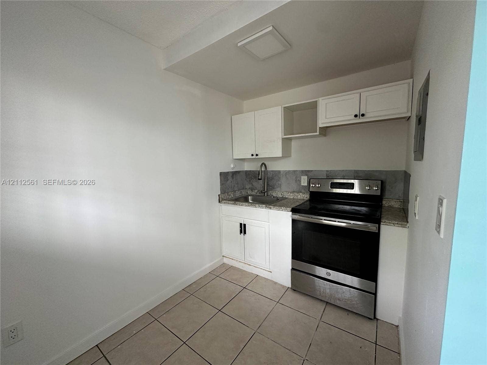 6901 NW 8th Avenue, #2, Miami, Miami, FL 33150 Kitchen featuring white cabinetry, stone-finish countertops, stainless steel range, gooseneck faucet, and tiled flooring