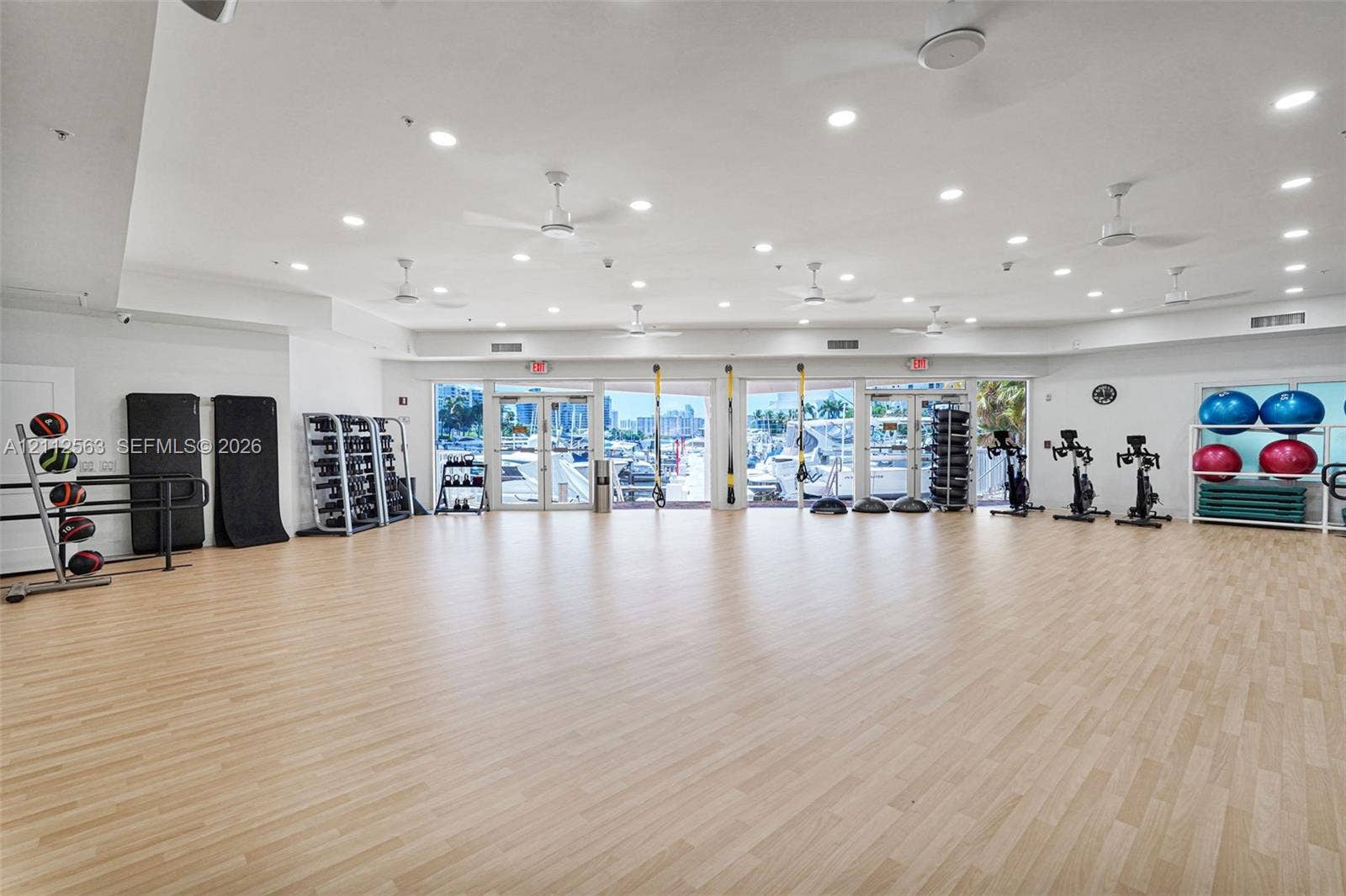 3330 NE 190th Street, #2016, Aventura, FL 33180 Fitness room featuring wood-finish flooring, recessed lighting, multiple ceiling fans, and full-height glass-paneled entry doors