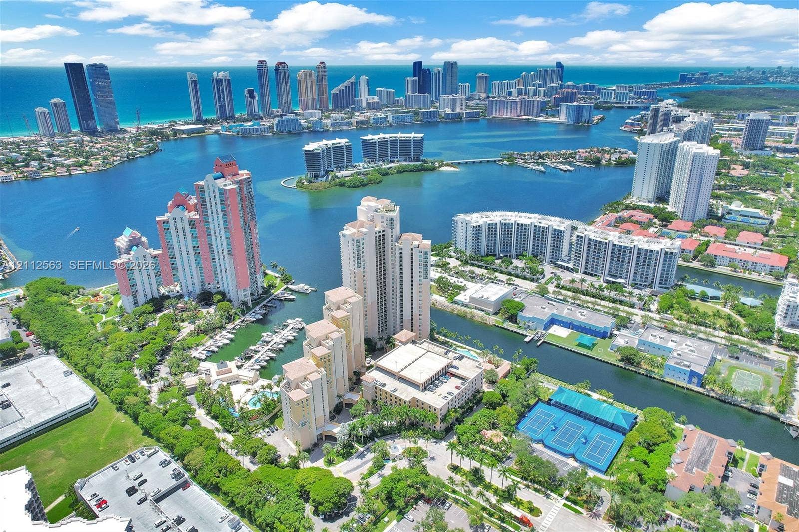 3330 NE 190th Street, #2016, Aventura, FL 33180 Aerial perspective featuring waterfront high-rise residential towers, private marina slips, hard-court tennis facilities, and expansive coastal waterways
