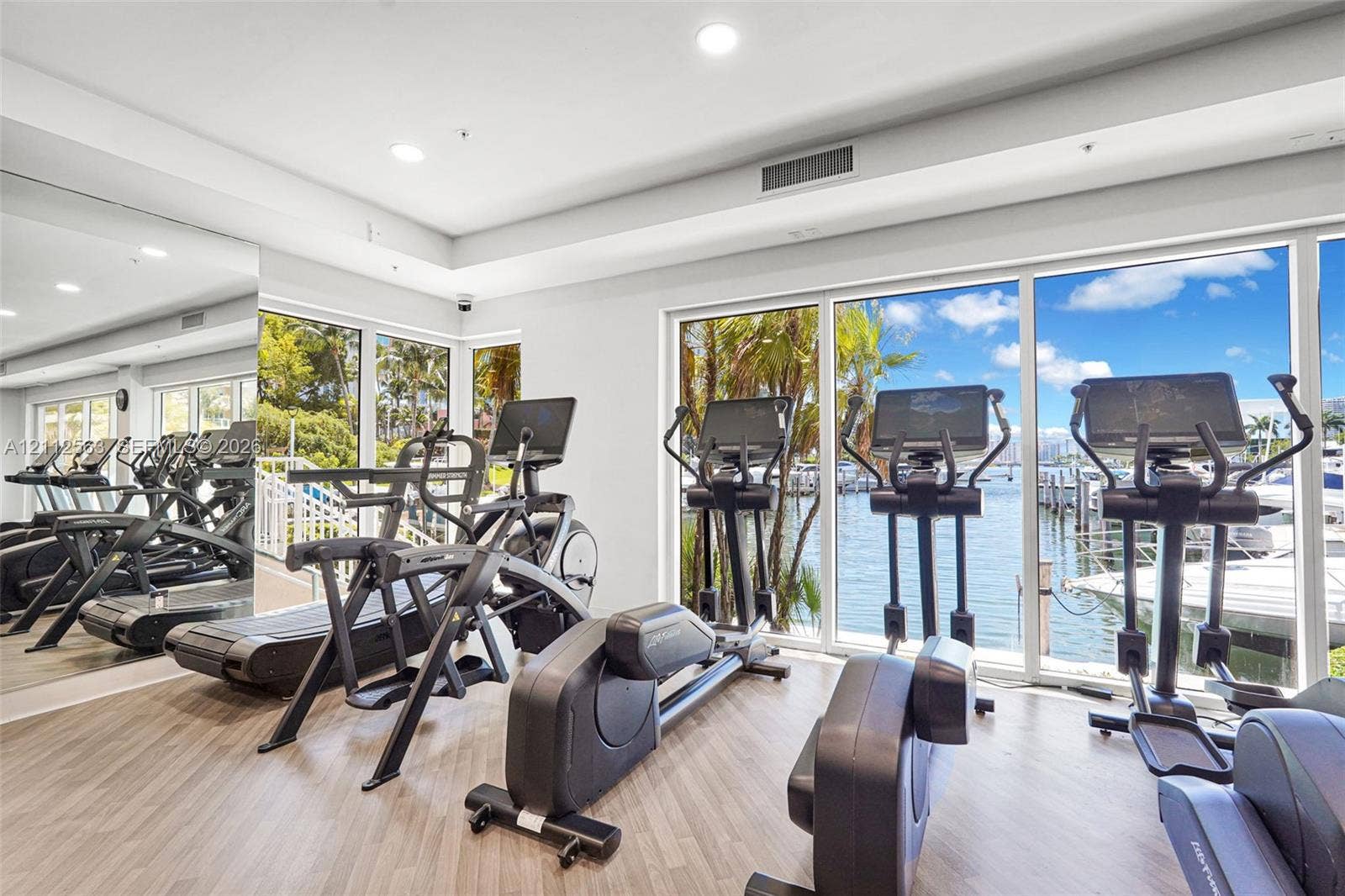 3330 NE 190th Street, #2016, Aventura, FL 33180 Fitness center featuring wood-finish flooring, floor-to-ceiling windows, and a full-wall mirror