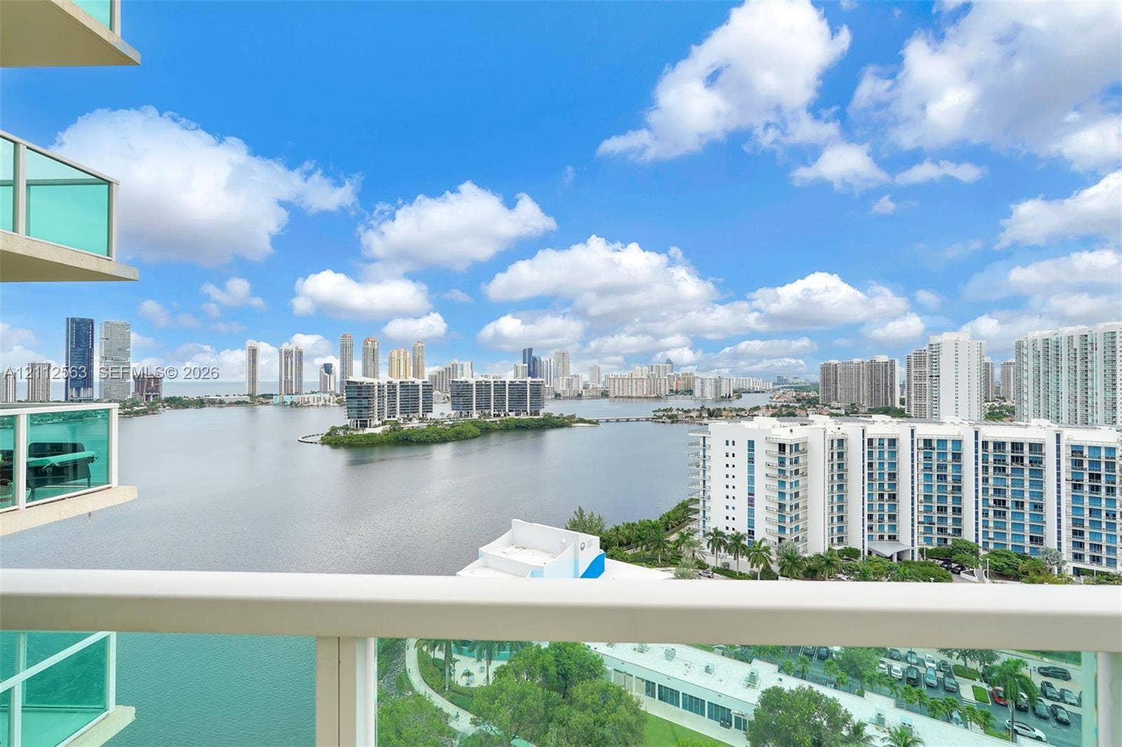 3330 NE 190th Street, #2016, Aventura, FL 33180 Covered balcony with glass railings, panoramic water and urban skyline backdrop