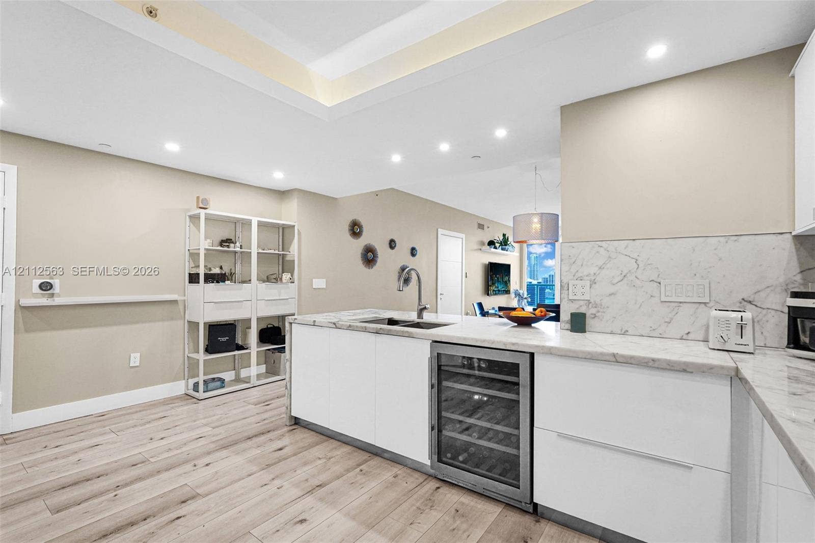 3330 NE 190th Street, #2016, Aventura, FL 33180 Kitchen featuring an island with stone countertops, a built-in wine refrigerator, recessed ceiling lighting, and wood-finish flooring