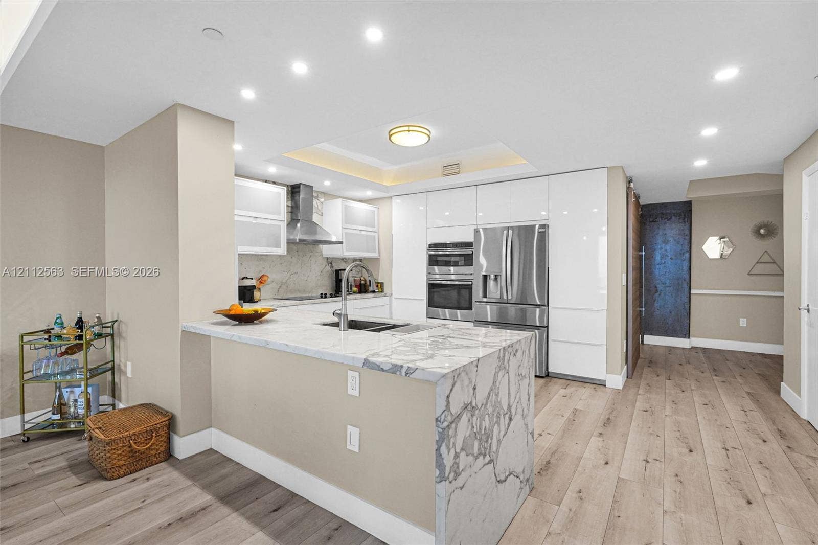 3330 NE 190th Street, #2016, Aventura, FL 33180 Kitchen featuring stone-finish waterfall edge countertops, gloss-finish cabinetry, built-in stainless steel double wall ovens, recessed ceiling lighting, and wood-finish flooring