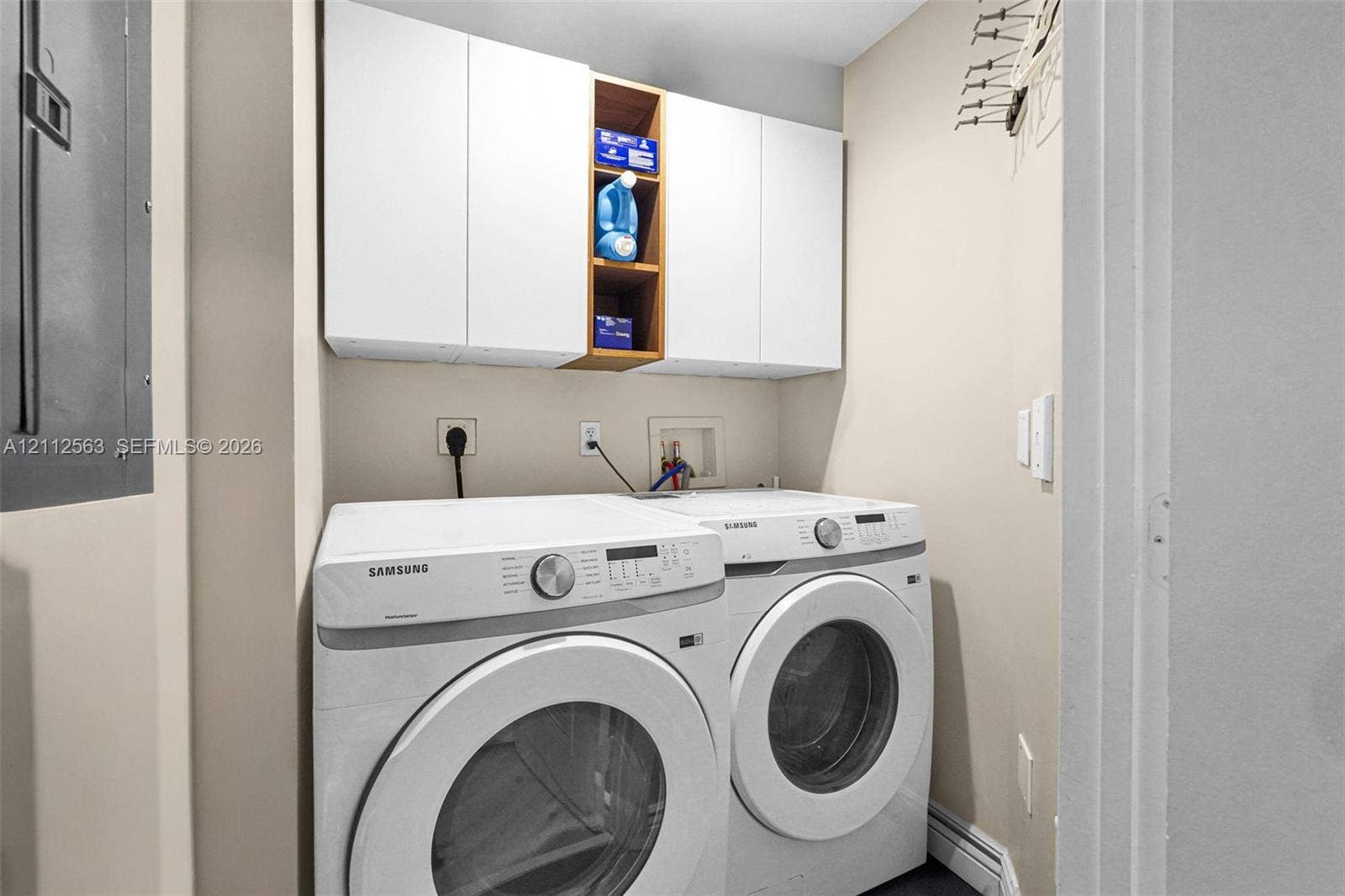 3330 NE 190th Street, #2016, Aventura, FL 33180 Laundry area featuring white cabinetry with integrated open shelving and dedicated appliance hookups