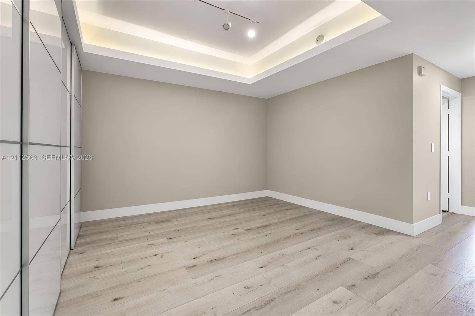 3330 NE 190th Street, #2016, Aventura, FL 33180 Tray ceiling featuring recessed lighting, wood-finish flooring, and floor-to-ceiling built-in cabinetry with a glossy finish