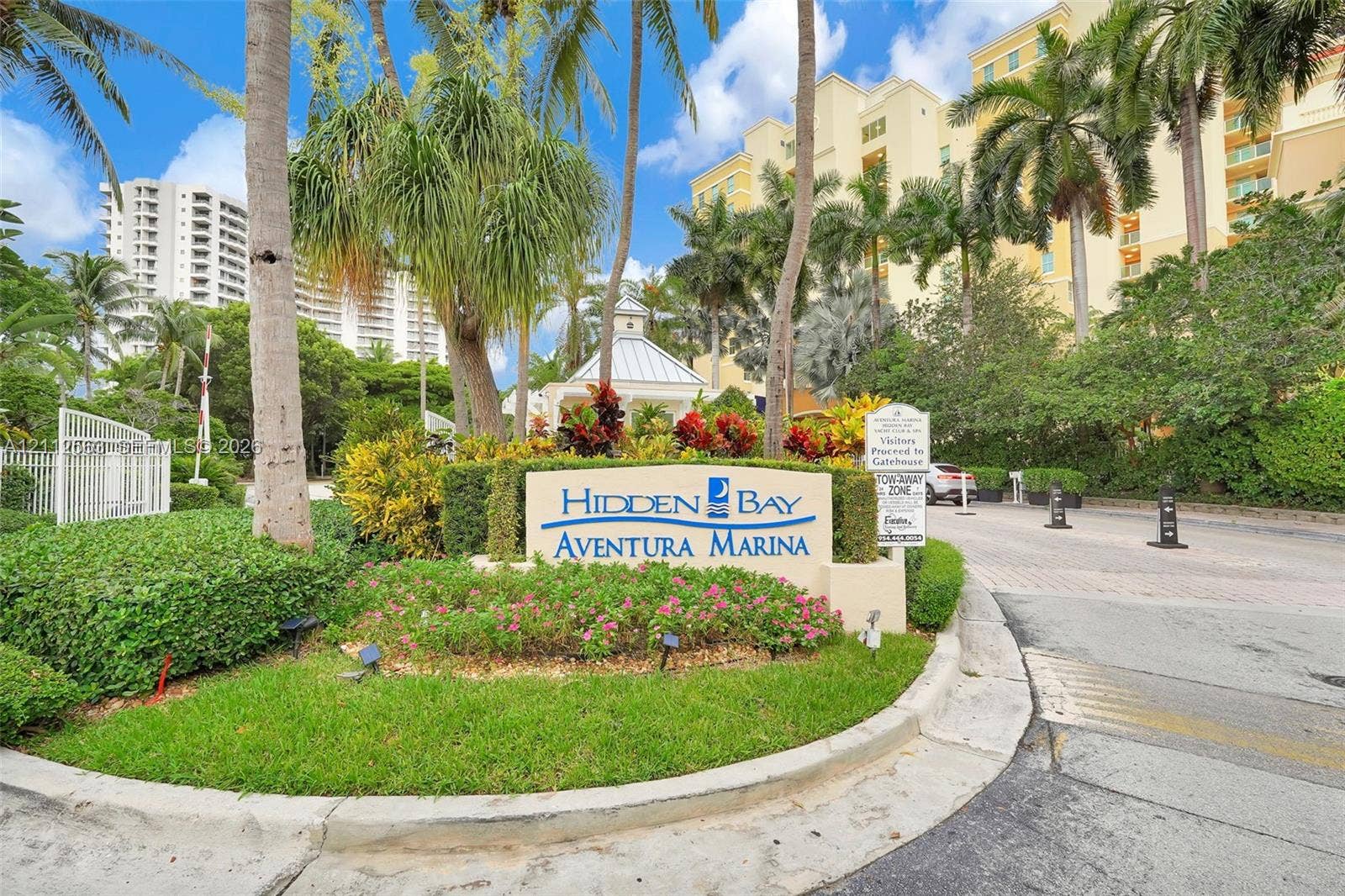 3330 NE 190th Street, #2016, Aventura, FL 33180 Gated entry featuring stone-finish monument signage, manicured tropical landscaping, and mature palm trees
