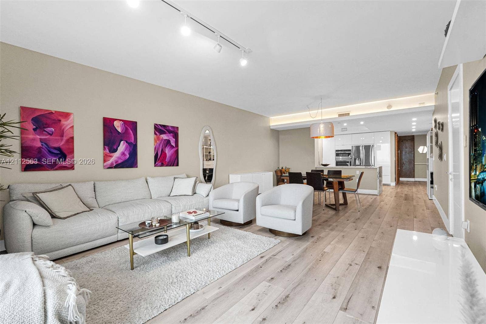 3330 NE 190th Street, #2016, Aventura, FL 33180 Living area featuring wood-finish flooring, recessed lighting, track lighting, and cove ceiling detail with integrated illumination