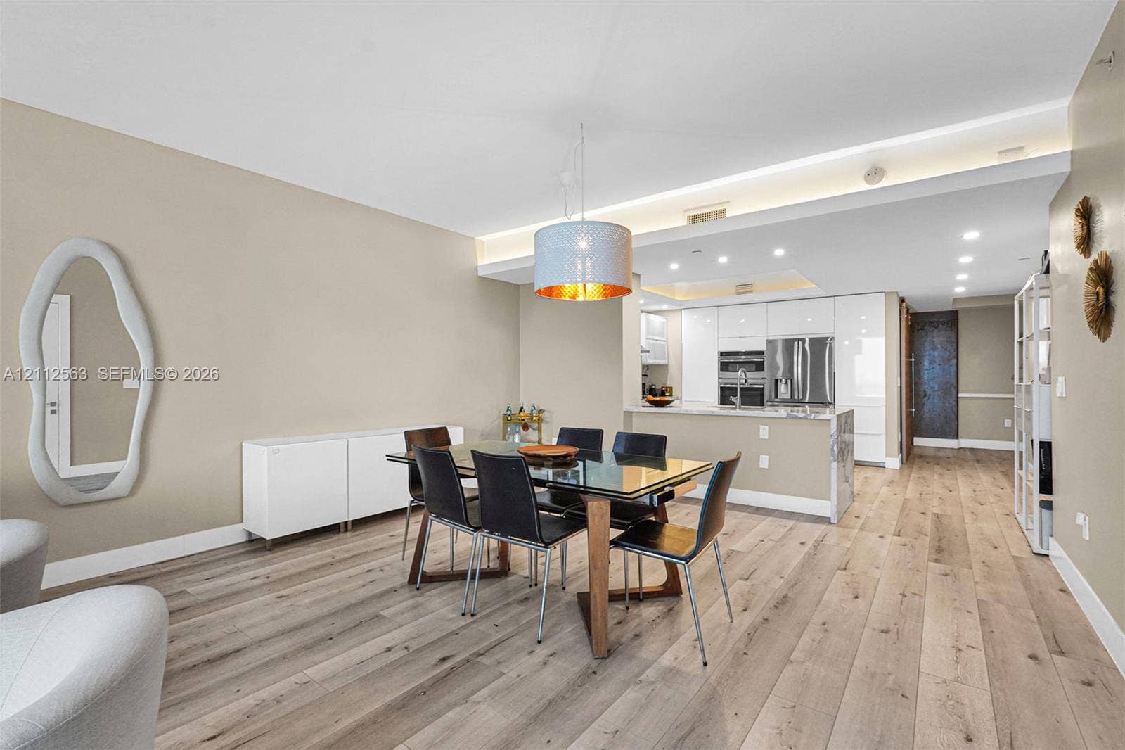 3330 NE 190th Street, #2016, Aventura, FL 33180 Open-concept interior featuring light wood-finish flooring, recessed ceiling lighting, a contemporary pendant light fixture, and high-gloss white cabinetry