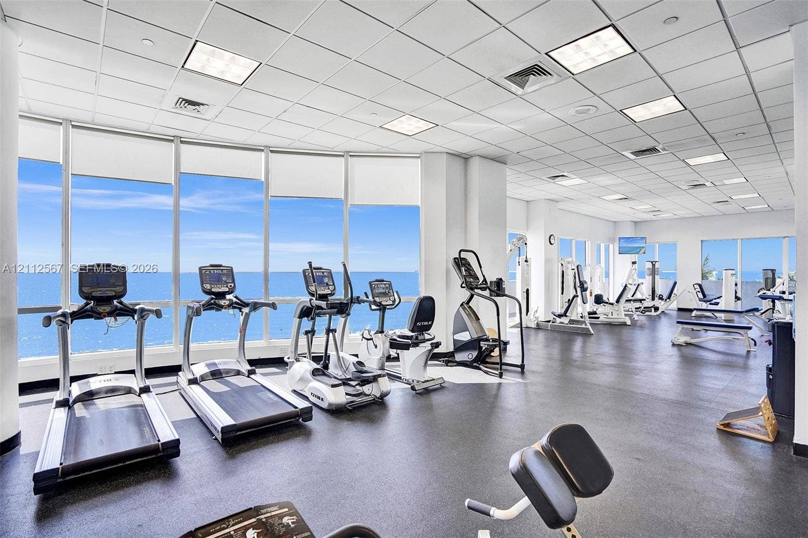 6365 Collins Avenue, #3208, Miami Beach, Miami Beach, FL 33141 Fitness center featuring floor-to-ceiling windows, rubberized flooring, and recessed ceiling grid lighting