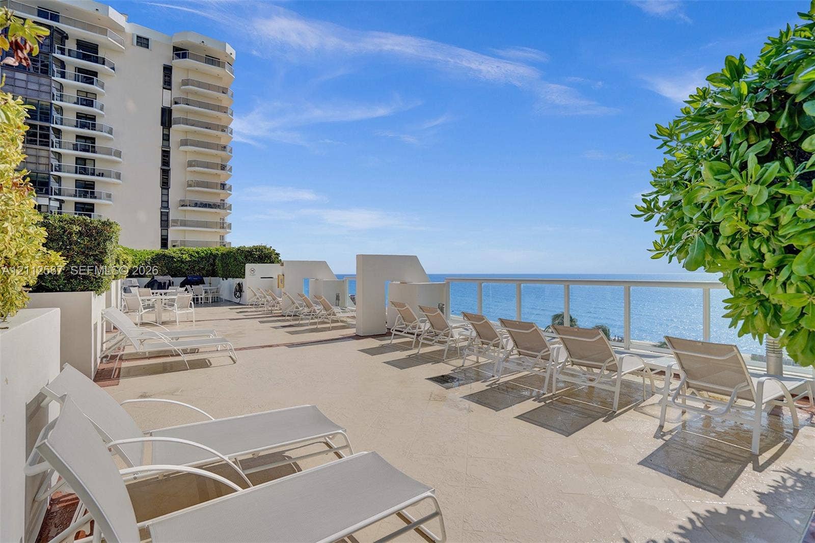 6365 Collins Avenue, #3208, Miami Beach, Miami Beach, FL 33141 Expansive open-air terrace featuring stone-finish flooring, glass-paneled railings, and oceanfront placement