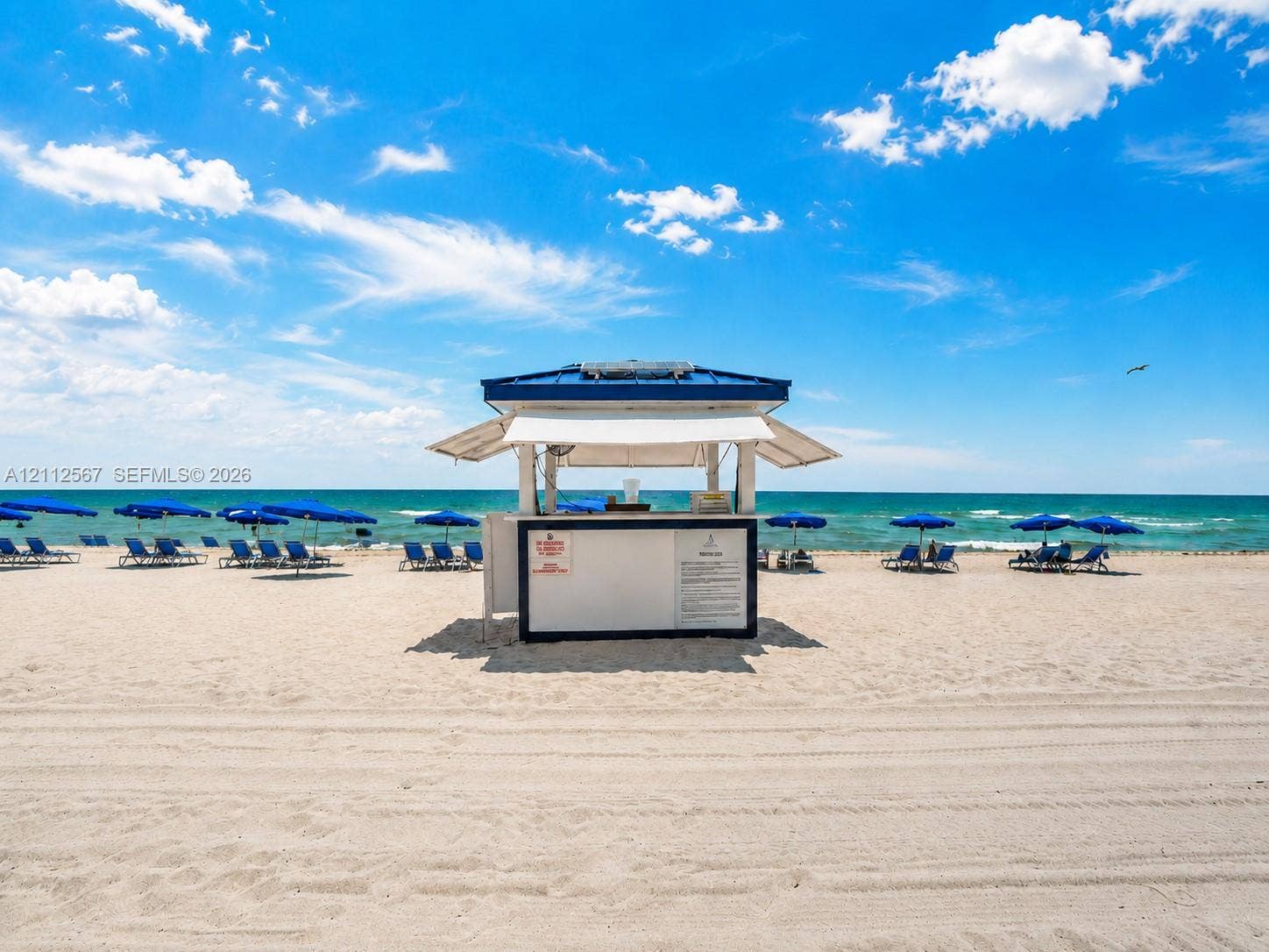 6365 Collins Avenue, #3208, Miami Beach, Miami Beach, FL 33141 Standalone beachside kiosk featuring a blue metal roof, white facade, and an open service window