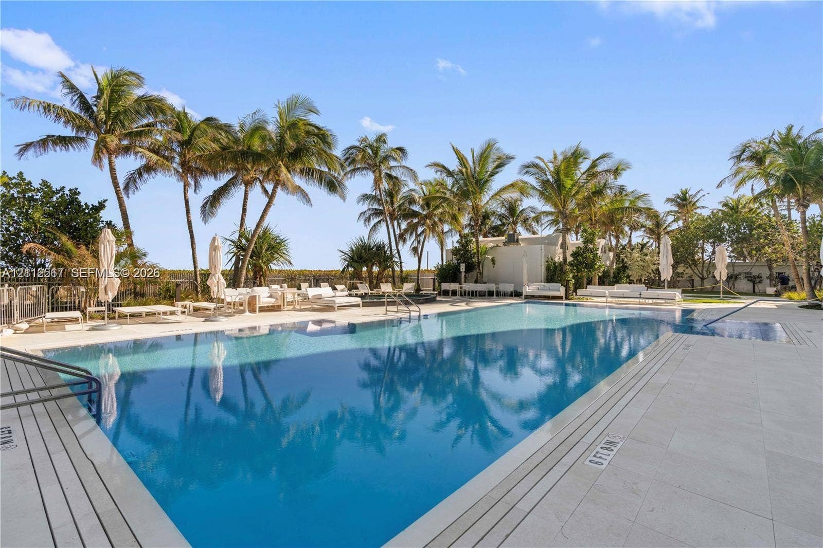 6365 Collins Avenue, #3208, Miami Beach, Miami Beach, FL 33141 In-ground swimming pool featuring a tiled waterline, large stone-paver pool deck, integrated steps, and mature palm landscaping
