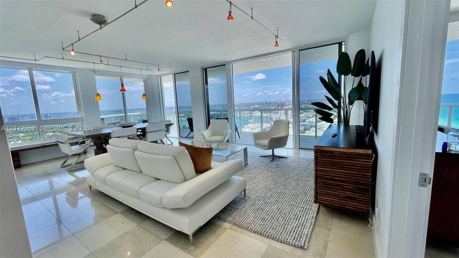 6365 Collins Avenue, #3208, Miami Beach, Miami Beach, FL 33141 Living area featuring floor-to-ceiling glass walls, stone-finish tile flooring, and overhead track lighting