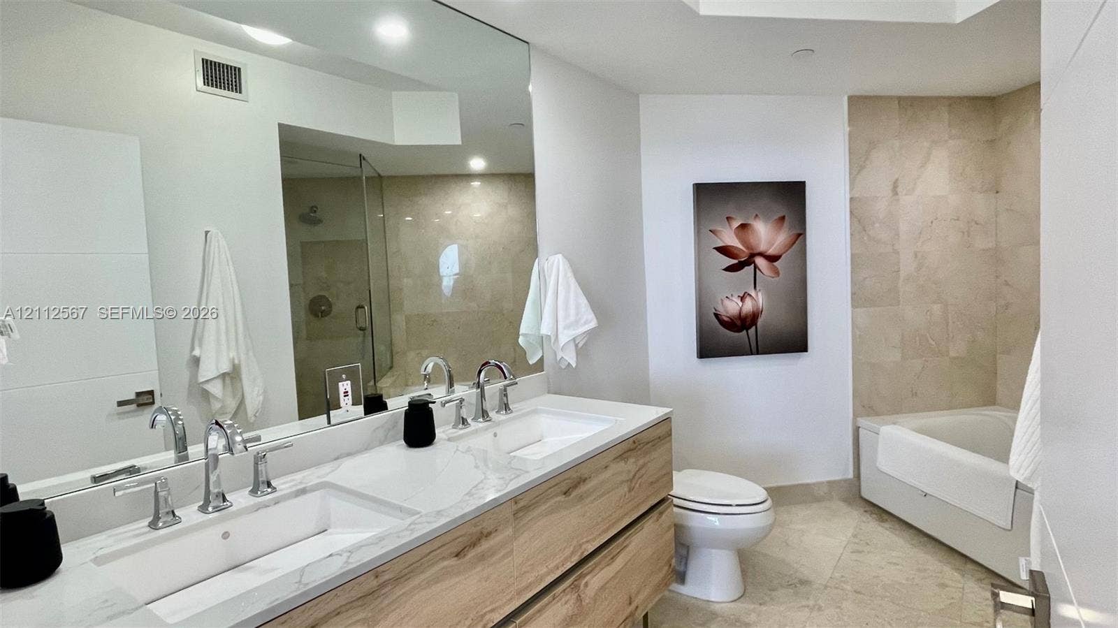 6365 Collins Avenue, #3208, Miami Beach, Miami Beach, FL 33141 Double floating vanity with integrated rectangular sinks, polished stone-finish countertop, wood-finish cabinetry, recessed lighting, and a walk-in glass-enclosed shower with tile surround