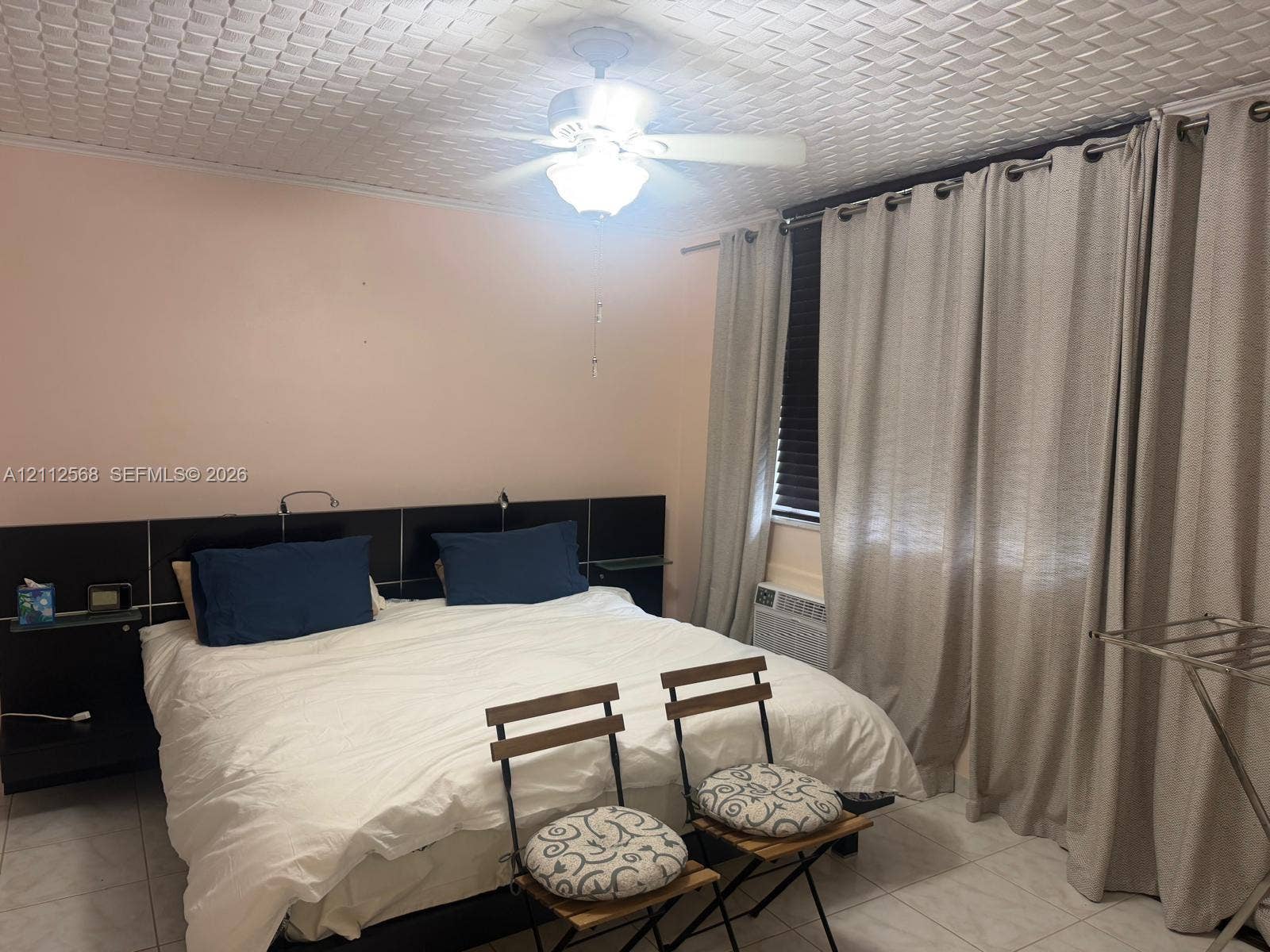 1936 S Ocean Drive, #8B, Hallandale Beach, Hallandale Beach, FL 33009 Textured ceiling, tile flooring, built-in black headboard with integrated shelving, and ceiling fan with integrated lighting