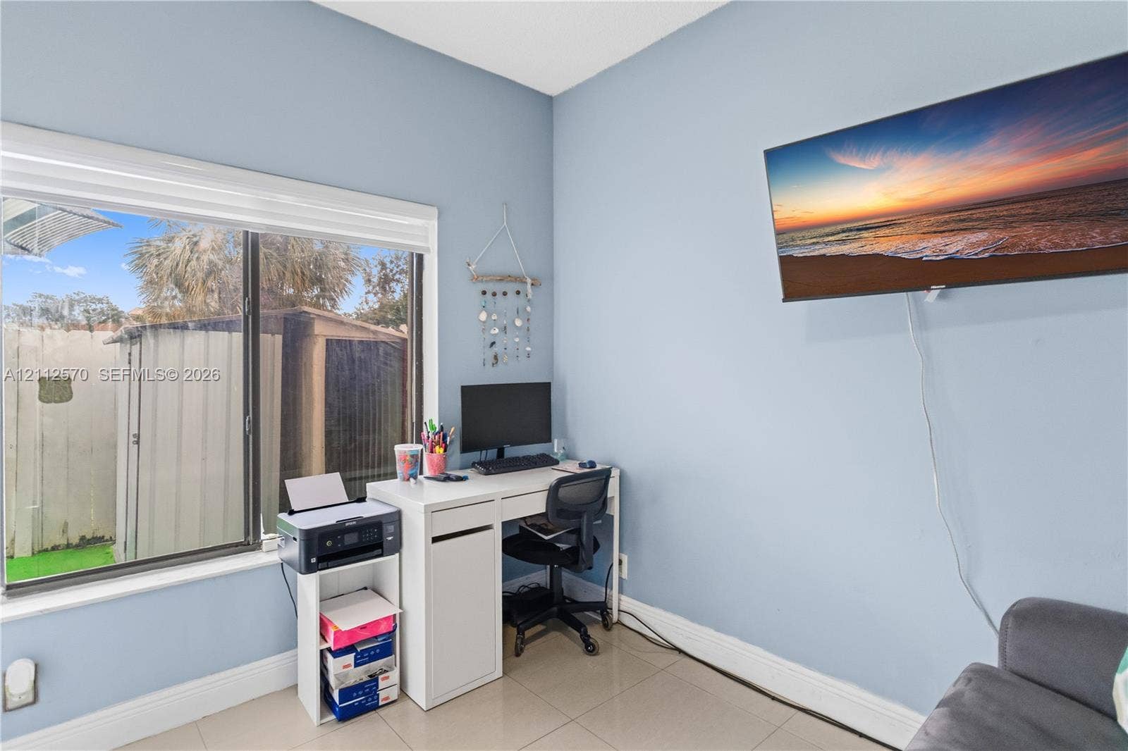 Neutral-tone interior featuring large-format tile flooring and a wide window with a white frame