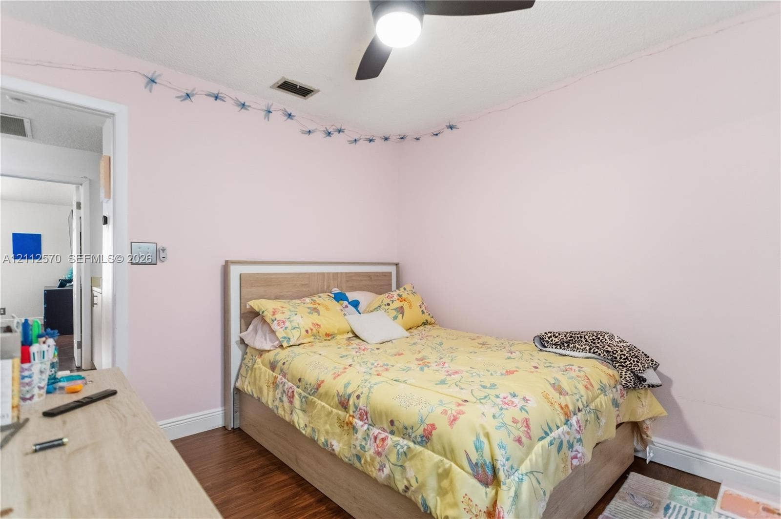 Wood-finish flooring and a central ceiling fan with an integrated light fixture