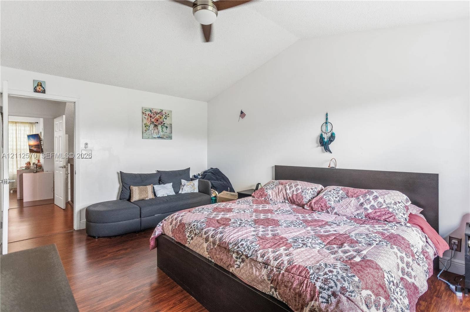 Vaulted ceiling, wood-finish flooring, and a ceiling fan with integrated lighting