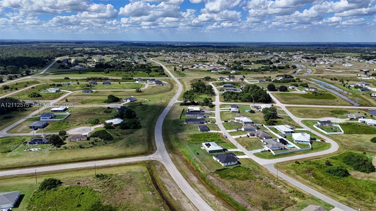 9041 E Broad, Labelle, FL 33935 Aerial perspective of residential area featuring paved streets, grass-covered lots, and residential structures with dark-toned roofing